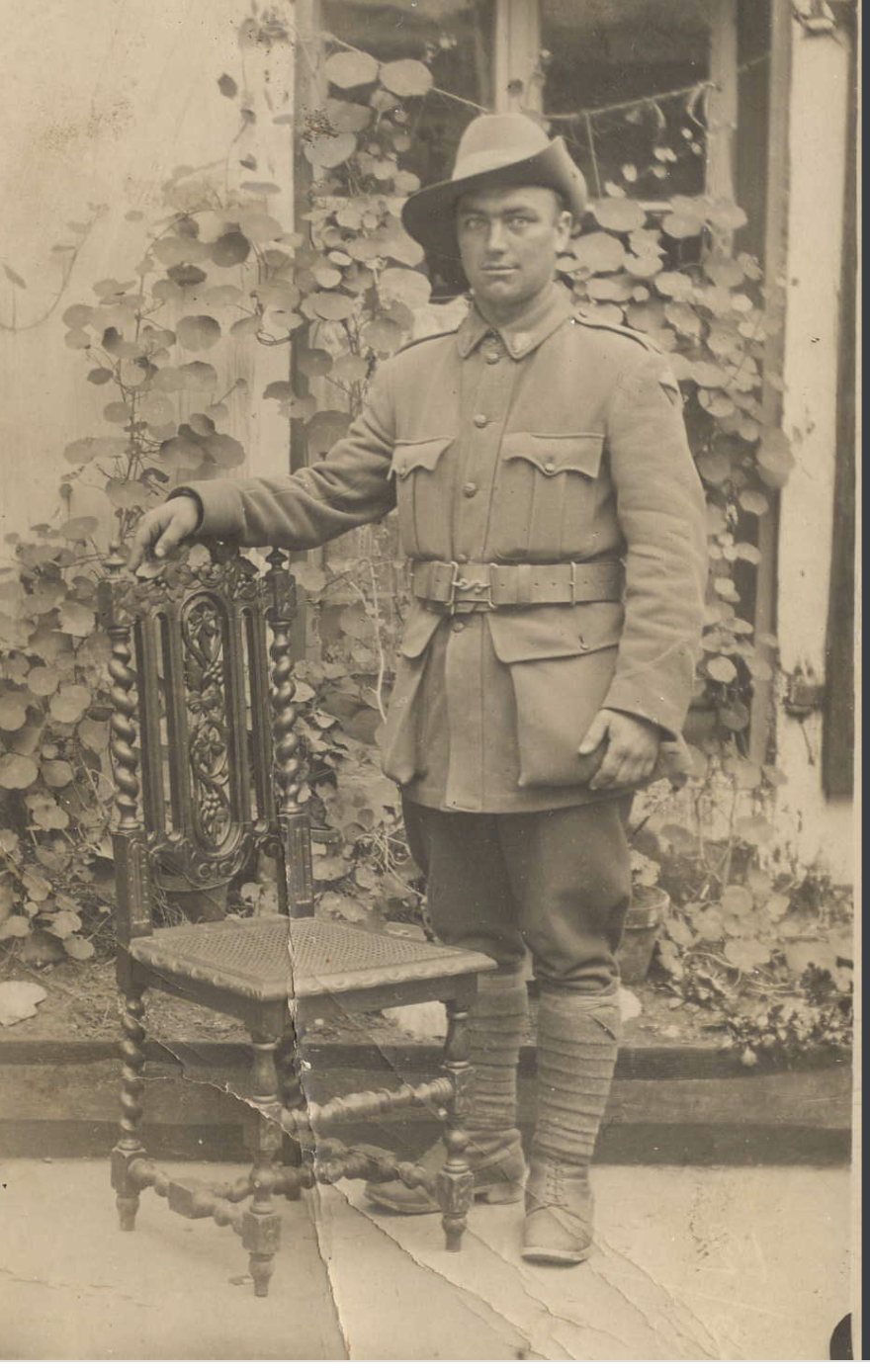 Soldier in slouch hat beside a carved chair